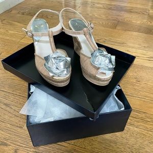 Beige strappy sandals with silver flower detail.